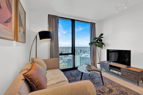 Sunlit living room with panoramic Level 51 city views