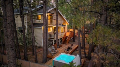 Back Deck - Backyard surrounded by trees with hot tub, deck, and seating to enjoy