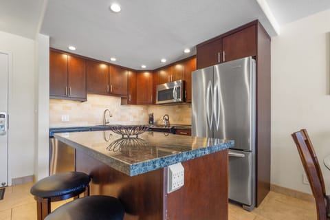 Your fully equipped kitchen features granite countertops, stainless steel appliances, and a breakfast bar perfect for morning coffee or casual meals.