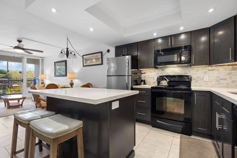 Gather around this elegant kitchen island with modern appliances and stylish seating - perfect for cooking together and sharing meals.