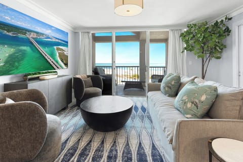 Unwind in this stylish living room where coastal artwork meets ocean views through your private balcony doors.