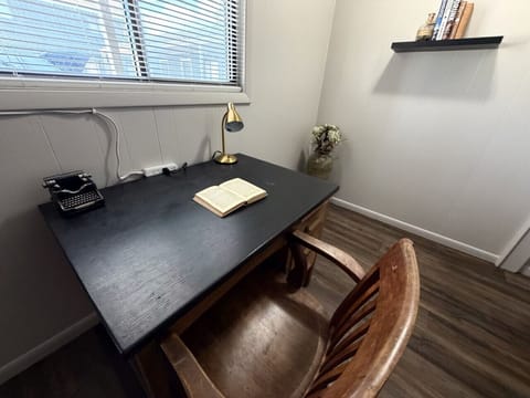 Vintage writing desk with antique typewriter, brass lamp, and open book