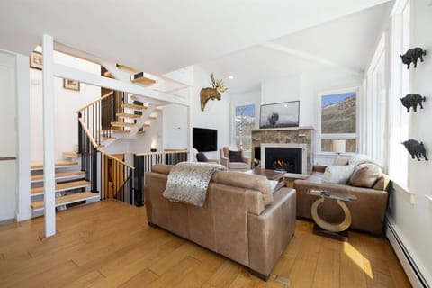 Stunning open-concept living room with epic Gore Range views, fireplace, Smart TV, and expansive windows that fill the space with natural light