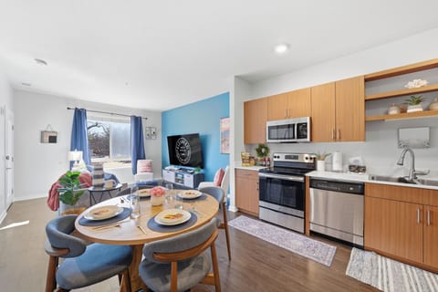 Bright, open-concept living area with stylish decor, a full kitchen, and a dining nook perfect for shared meals.