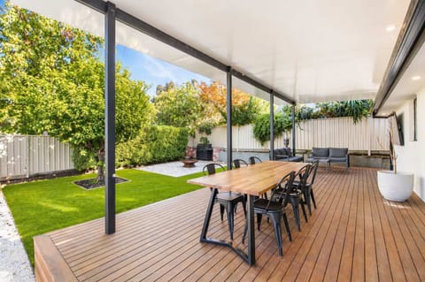 Covered outdoor deck with BBQ, fire pit and TV.