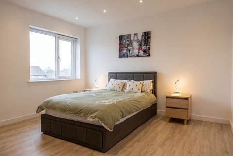 Bright double bedroom with Paris-inspired art and warm bedside lamps to ease you into each morning.