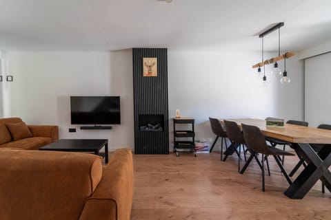 Living room with view of the TV, fireplace, and dining table