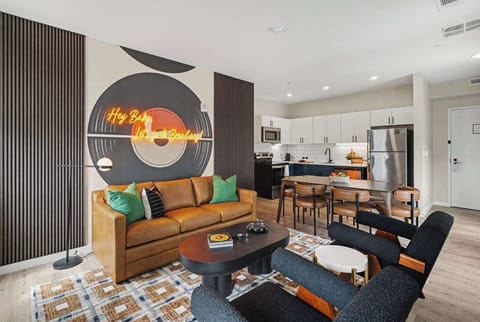 Bright and open living area featuring a smart TV and plush furnishings. Connects to the dining area and kitchen.