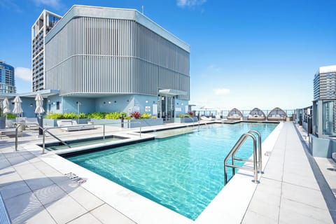 Rooftop pool area with modern lounge seating and city views.
