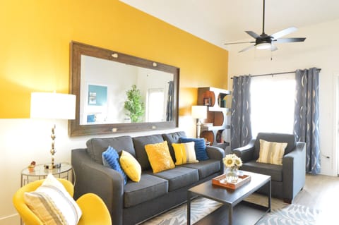 Living room with sofa bed, accent chair, and huge mirror. 
