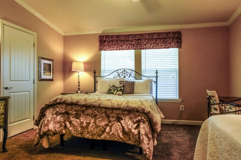Cozy bedroom with warm décor, plush carpet, and bright natural light