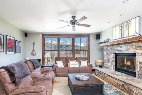 Cozy up by your crackling fireplace while mountain peaks frame your perfect winter retreat through expansive windows.