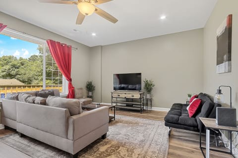 Welcome to Bethany Grove House Unit A! The bright living room features a large sectional and comfortable seating, creating a great space to relax, watch TV, or spend time together.