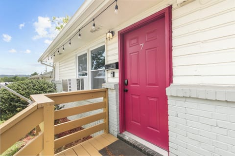 Your stay starts here—Flat No. 7, marked by the bright pink door up a flight of steps, so you know you’ve arrived.