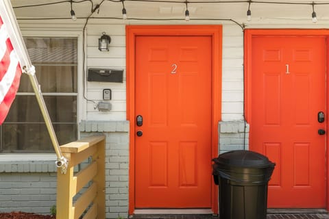 Your stay starts here—Flat No. 2, marked by the bright orange door so you know you’ve arrived.