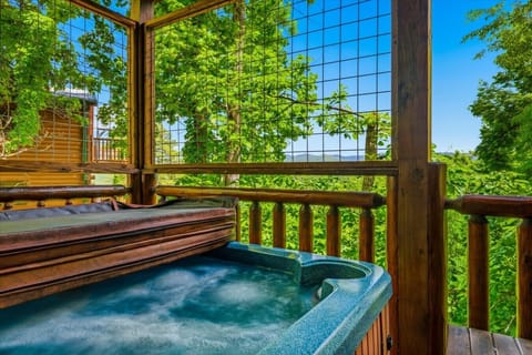 Relax in the bubbling hot tub while taking in peaceful mountain views and the surrounding forest from this private covered deck retreat.