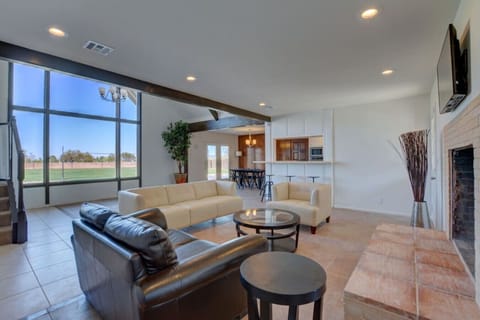 Open-concept living room with floor-to-ceiling windows and views of compound
