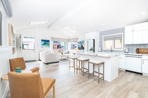 Bright, open-concept living and kitchen area featuring updated flooring, custom cabinetry, and brand-new appliances throughout.
                