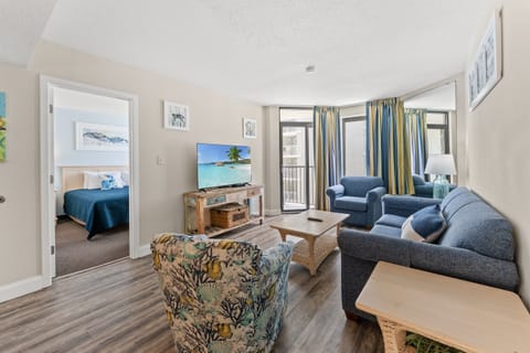 Large living room area with sleeper sofa, access to the balcony and large screen TV