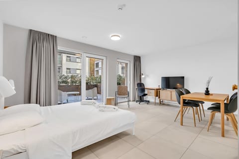 Bright open-plan studio with a comfortable bed, dining area, and plenty of natural light for a relaxing stay.