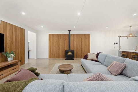 Large living room with flat screen TV, ample seating and indoor gas fireplace 