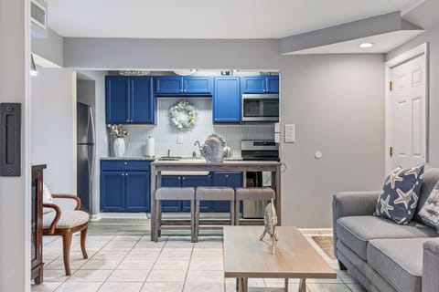 Cozy living area with a modern kitchen featuring blue cabinetry and a breakfast bar.