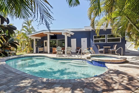 Your private tropical oasis awaits with a sparkling pool and hot tub surrounded by swaying palms and comfortable lounge seating.