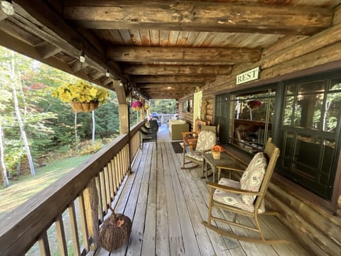 Unwind on your private covered deck with rustic charm, surrounded by peaceful forest views and cozy seating.