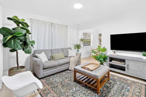 Bright and cozy living space with plush seating and a Smart TV, perfect for relaxing after a day out.