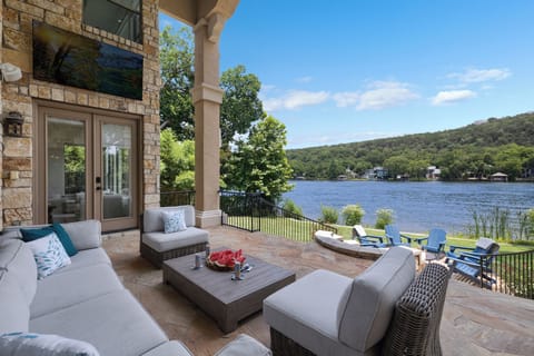 Covered stone patio opening straight onto the Lake Austin water