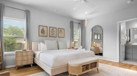 Primary suite with King bed, bedside reading lamps, and direct access to the ensuite bathroom.