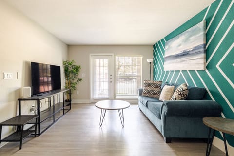 Bright modern living room with bold accent wall and cozy teal sofa