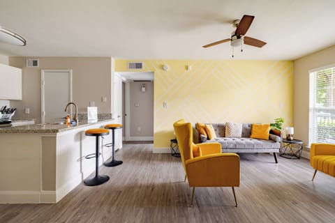 Bright open living space with chic decor, bar seating, and sunny accents