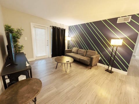 Modern living room with bold accent wall, cozy seating, and TV lounge area