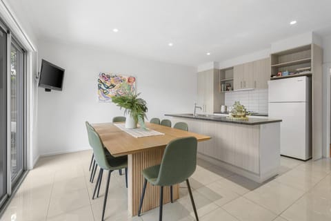 Bright kitchen-diner with island, seating for 6, and patio access.