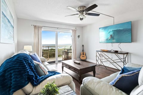 Bright & airy living room with sliding glass doors that lead to an outdoor direct oceanfront balcony