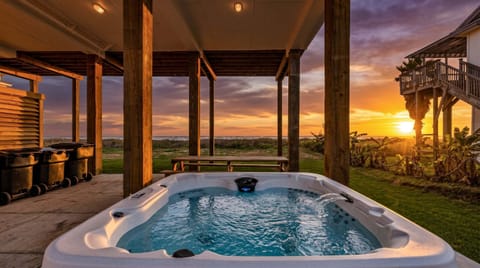 Private outdoor hot tub with panoramic beachfront views under a covered patio, ideal for luxury Galveston beach house getaways and relaxing coastal