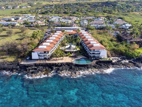 Oceanfront resort property featuring two wings with red-tile roofs, swimming pool, and direct access to pristine turquoise waters along Hawaii's coastline.