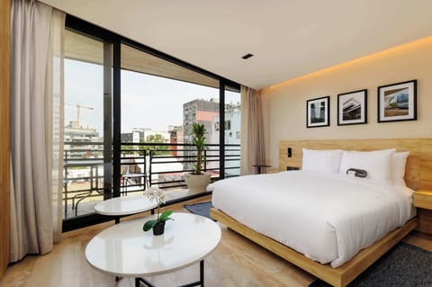 Bright modern bedroom with a large bed, natural light, and a balcony view.