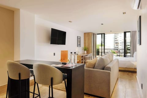 Bright open-concept living area with kitchen and bar seating, perfect for socializing.
