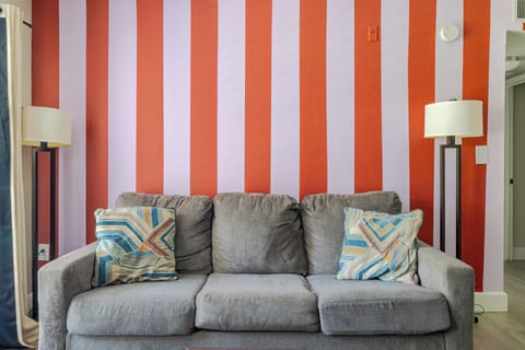 Stylish lounge nook with bold striped wall and comfy gray sofa