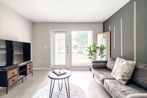 Bright modern living room with TV, natural light, and stylish accents