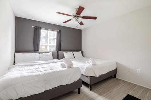 Bright bedroom with two double beds, natural light, and a clean modern feel