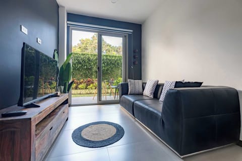 Living area with sofa, TV and garden access