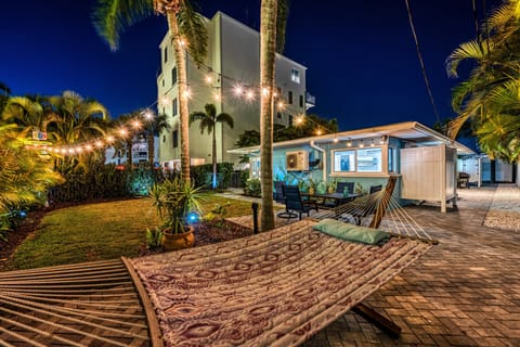 The shared backyard comes alive at night with café lights and tropical landscaping.