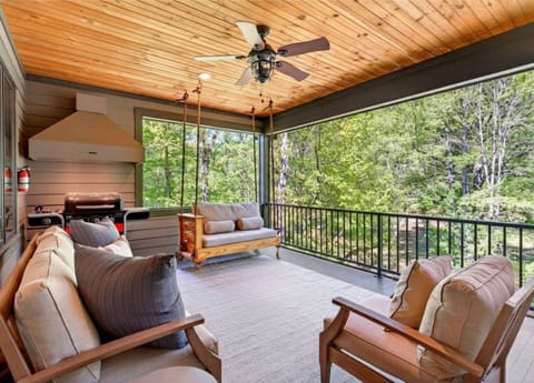 Screened-in porch with seating, daybed swing, and gas grill