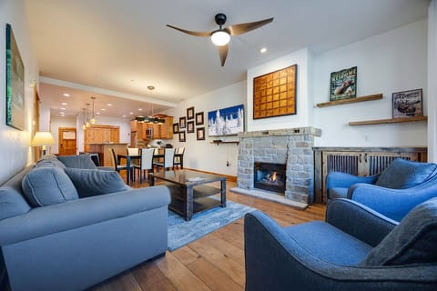 Sink into plush blue sofas beside your crackling stone fireplace, while the open kitchen invites culinary adventures in this stylish retreat.
