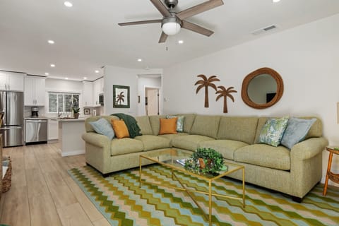 Sink into your spacious sectional sofa in this bright, tropical-themed living space where comfort meets style perfectly.