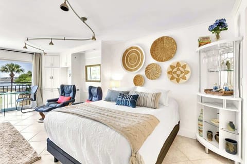 Drift off to sleep in your coastal haven with handwoven basket art above the plush bed and poolside balcony doors that invite morning breezes.