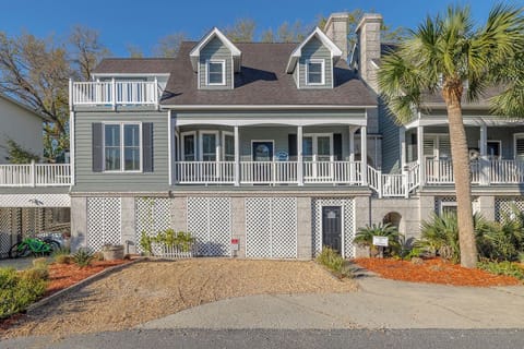Coastal charm meets comfort at this elevated beach house with wraparound porches and tropical landscaping.
